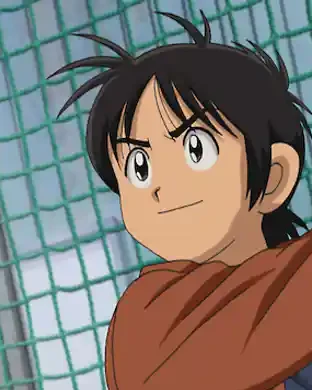 Ko reaches upwards in front of baseball practice netting.