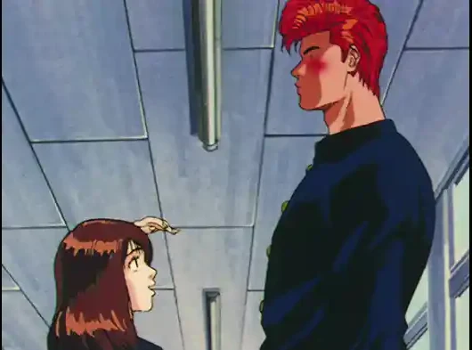 Haruko looks up at the tall, red-haired Hanamichi in a school corridor.