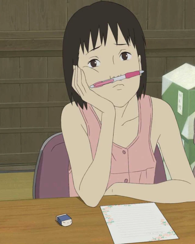 Momo rests her head in one hand with a pen beneath her nose.