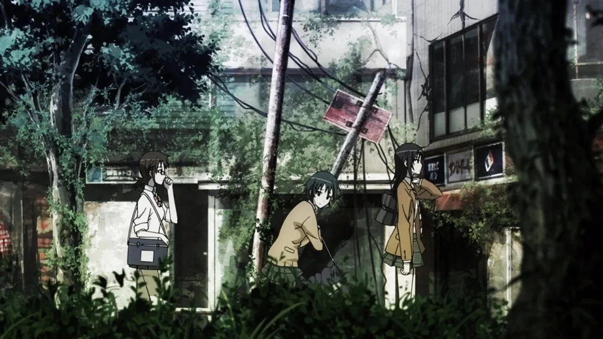 The three uniformed rescuers walk past overgrown buildings and leaning street signs.