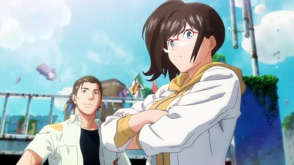 A dark-haired woman with glasses stands with her arms folded near a man and outdoor structures.
