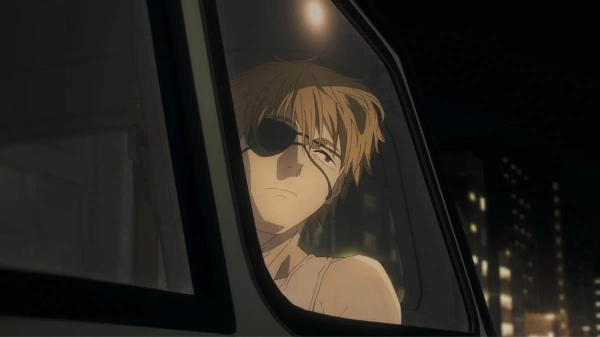 A tired blond young man with an eye patch looks out through a vehicle window.
