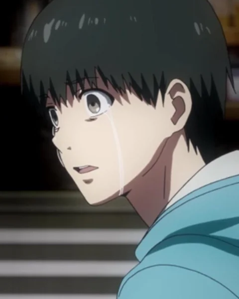 A dark-haired young man cries while looking over his shoulder in a pale blue jacket.