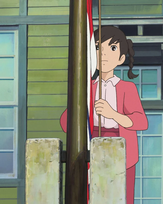 Umi raises signal flags beside a school building.
