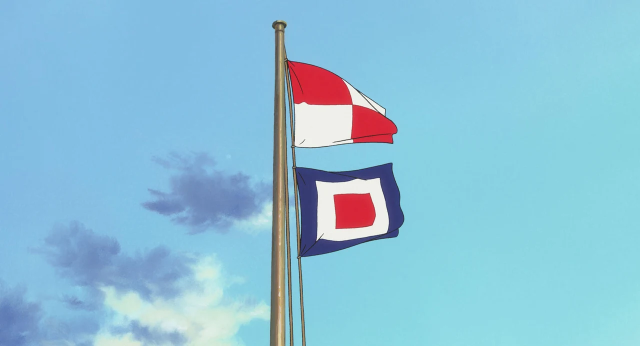 Two signal flags fly from a pole against a blue sky.