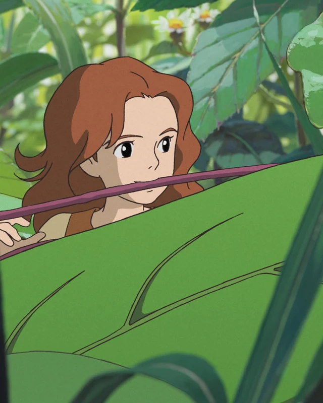 Arrietty peers between large green leaves.