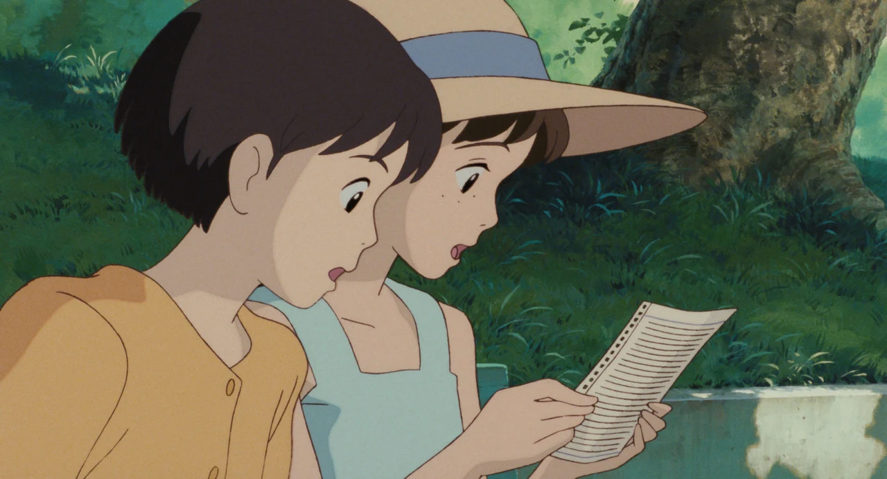 Shizuku and another girl study a printed page outdoors.