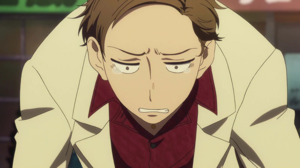 A young man leans forward with a strained expression.