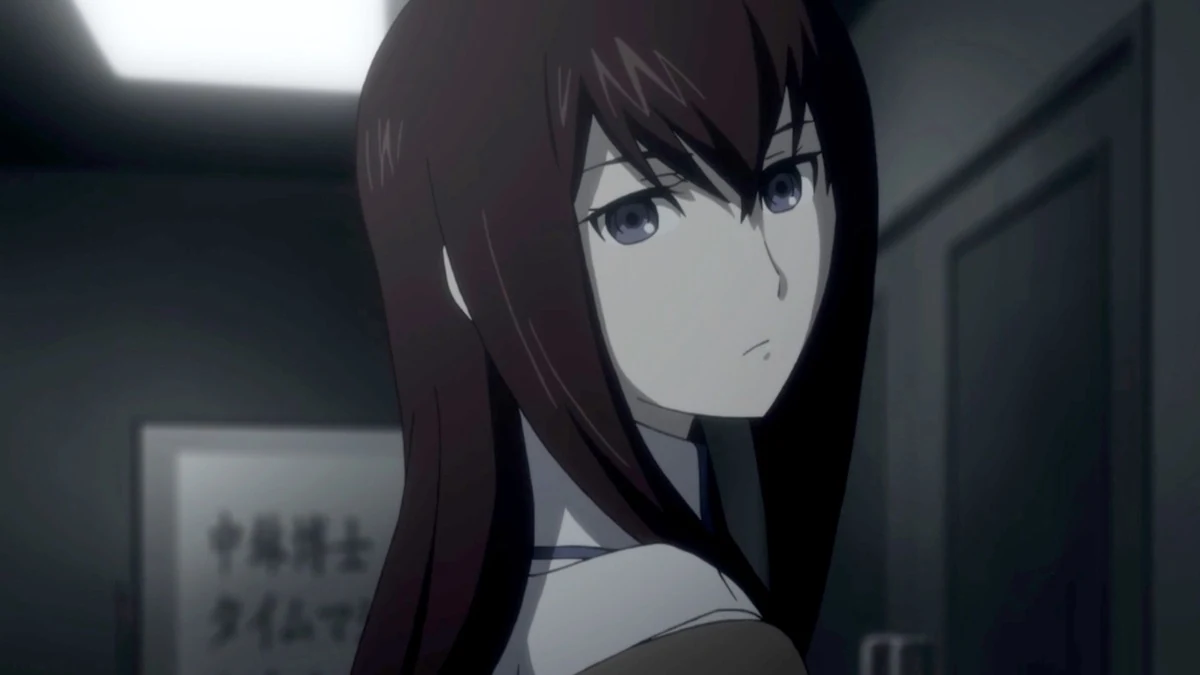 A red-haired young woman turns her head inside a dim room.