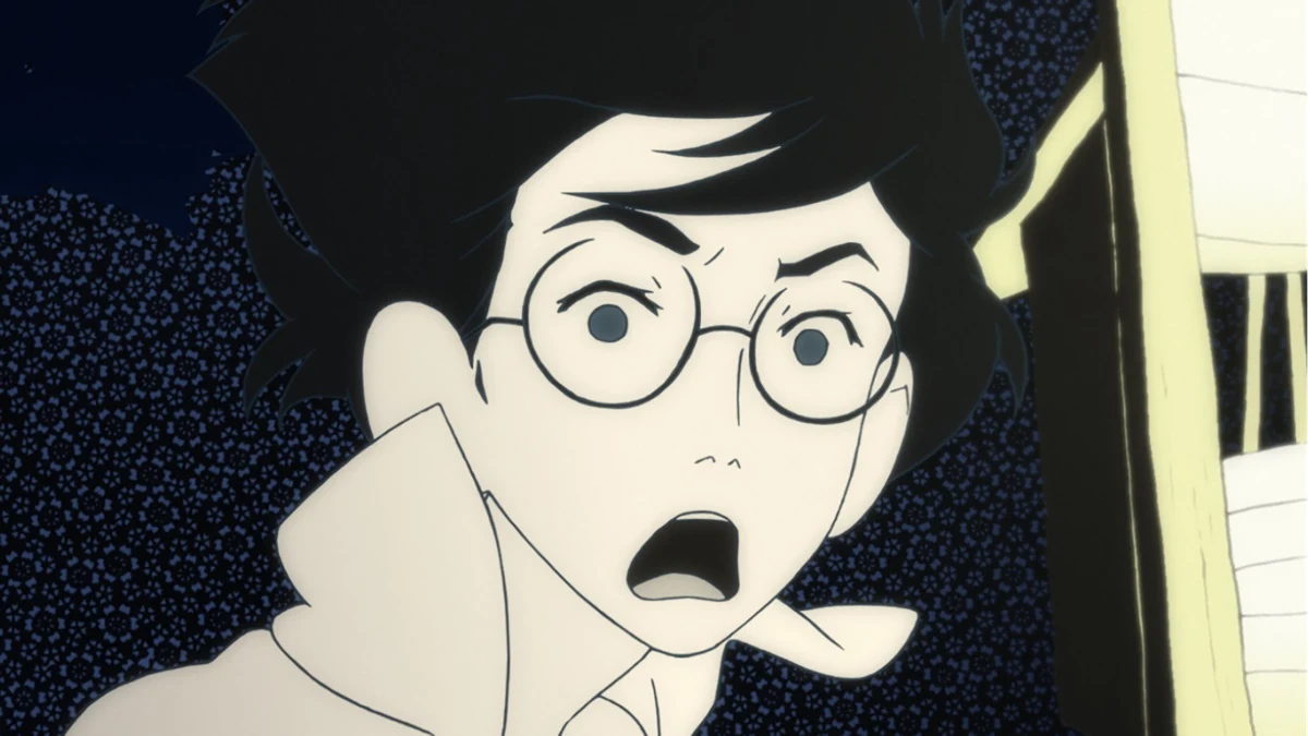 A bespectacled young man raises his hands in surprise.