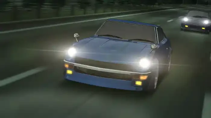 A blue Nissan Z drives along a lit expressway with another car following behind.