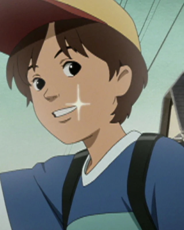 A boy in a cap smiles with his backpack on a street.