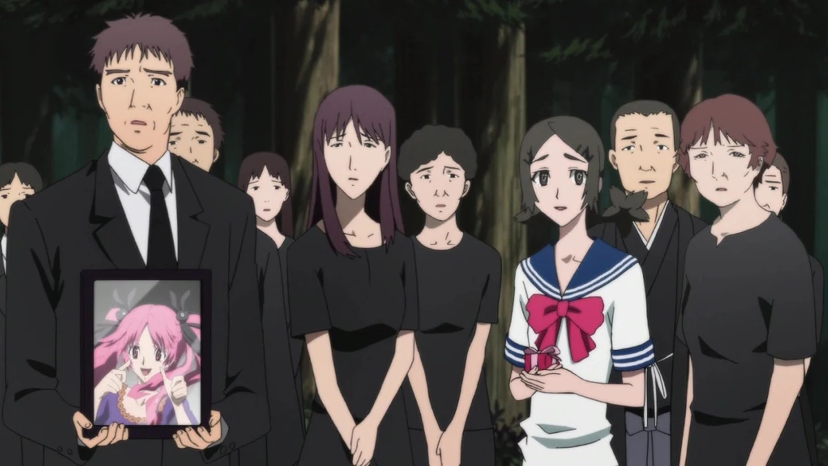 Villagers in dark clothes gather with a framed photograph.