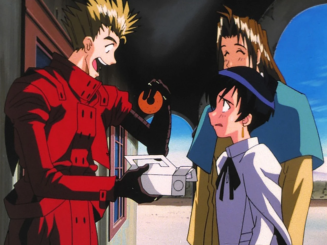Vash talks to two people beside a building.