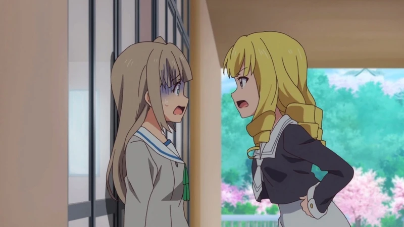 A blonde schoolgirl stands with hands on her hips in a corridor.