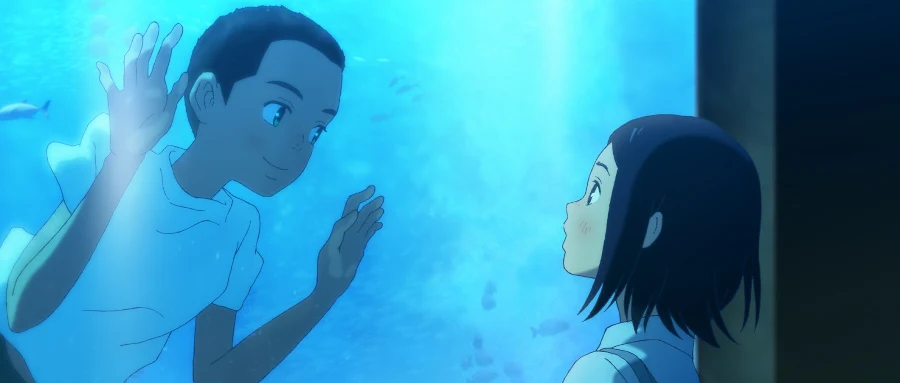 A boy and a girl look at one another through a blue aquarium window, with their hands raised toward the glass.