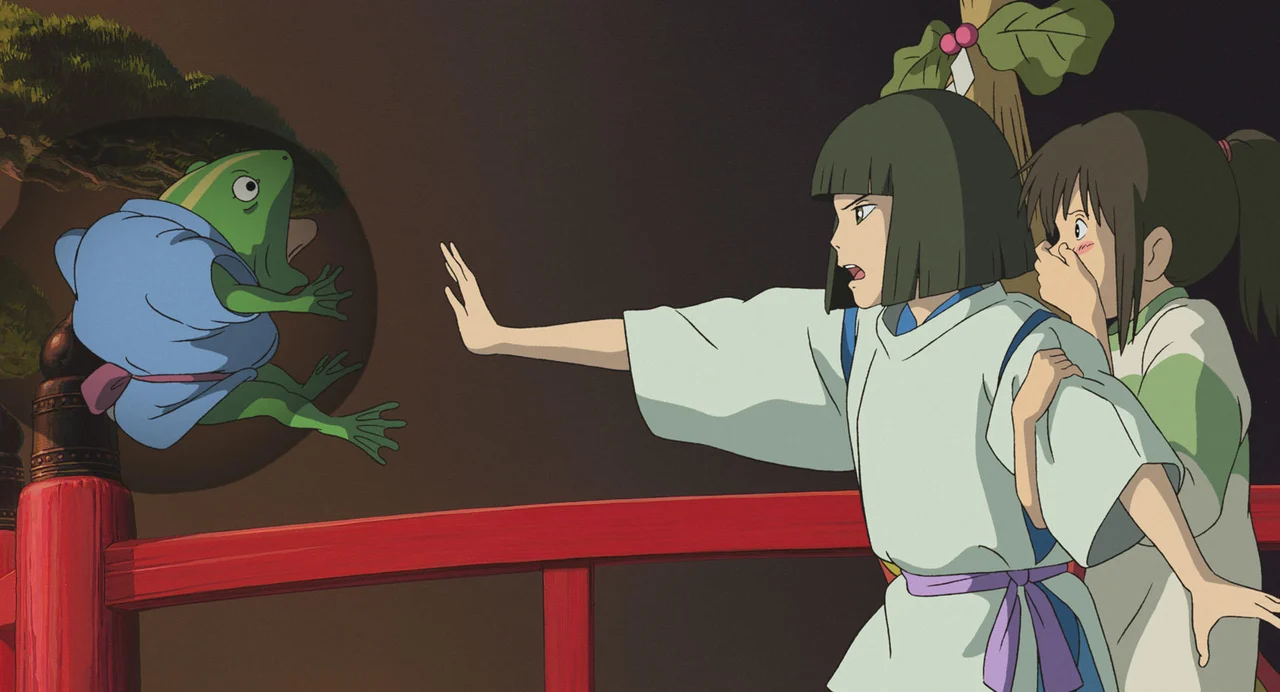 Haku holds out an arm as Chihiro stands close behind him in Spirited Away.