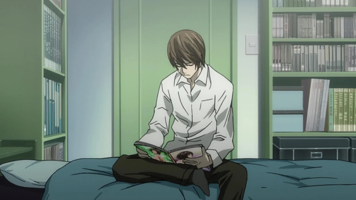 Light sits cross-legged on his bed reading a magazine, with bookcases and a stereo behind him.
