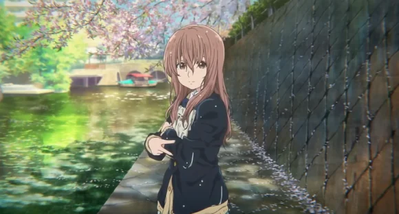 Shoko stands beside a sunlit canal under cherry blossoms, with one hand held across her chest.