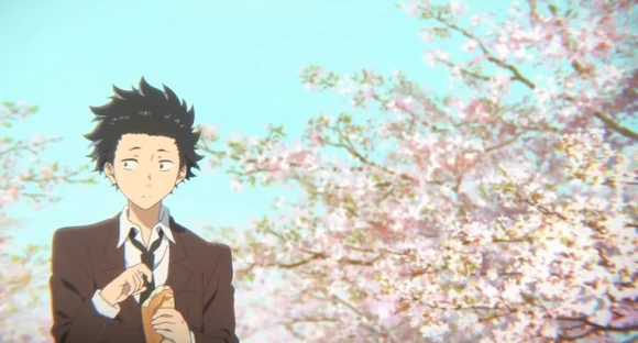 Shoya wears a brown school uniform and holds a small bag beneath flowering cherry trees.