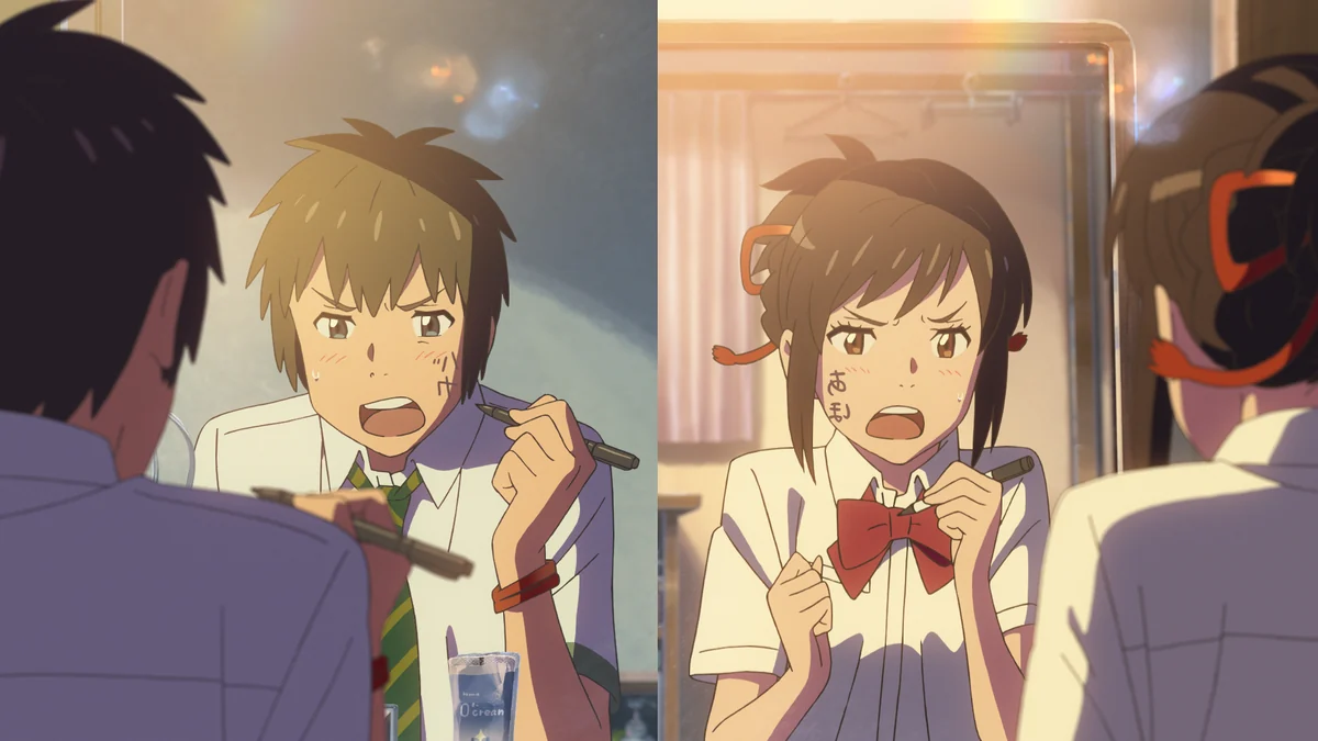 A split image shows Taki and Mitsuha facing mirrors, holding markers beside messages written on their cheeks.