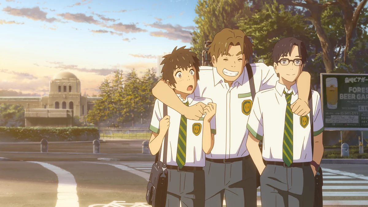 Taki stands with two school friends, the smiling boy between them resting his arms across their shoulders.