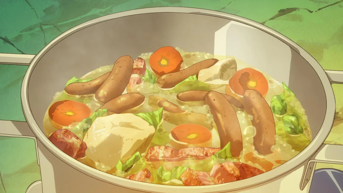 Sausages, cabbage, carrot and pieces of meat fill a steaming pot of broth.