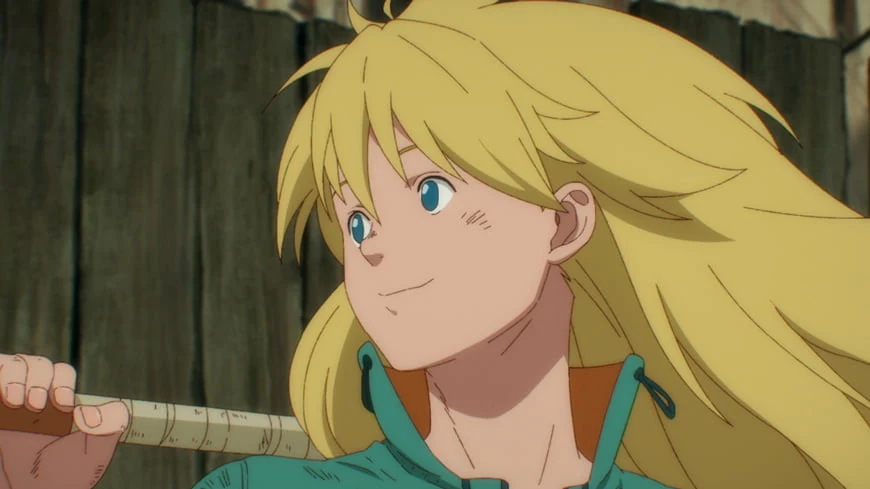 Nikaido, in a turquoise top, smiles with a long handle resting across her shoulder.