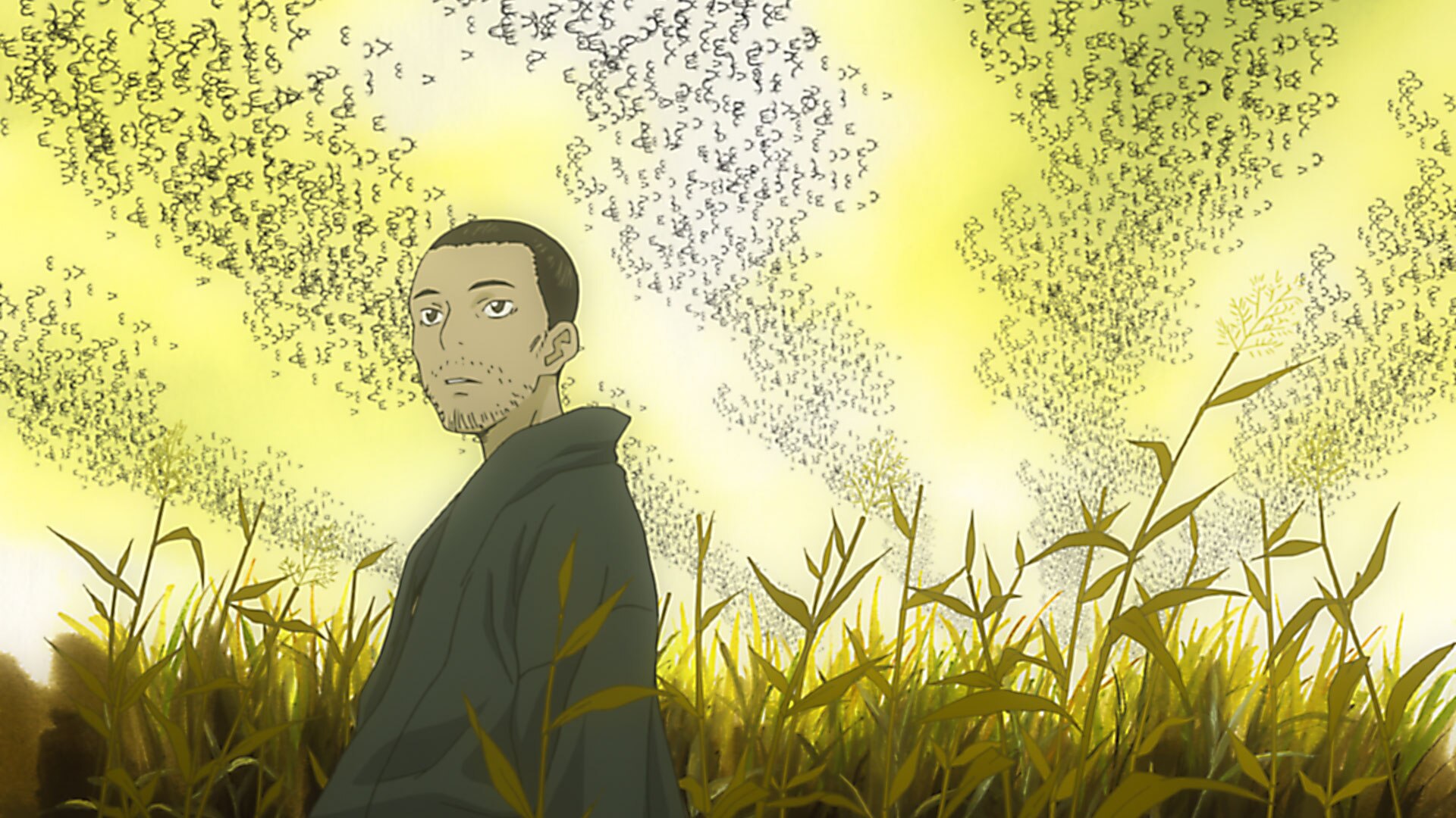 A dark-haired man stands among yellow-green plants beneath hanging trails of small dark shapes.