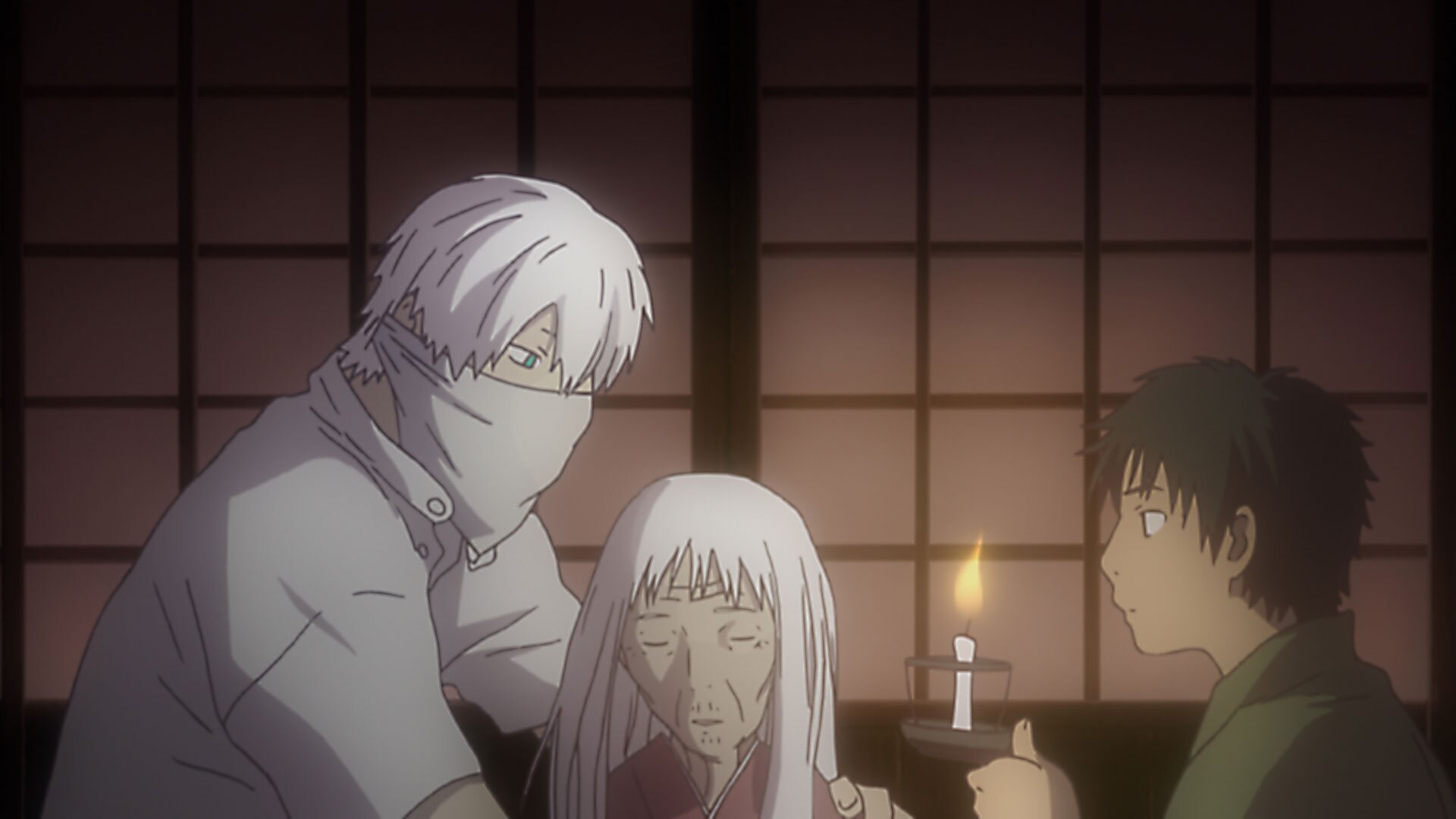 Ginko, with his lower face covered, sits beside a white-haired woman while a boy speaks across a candlelit room.