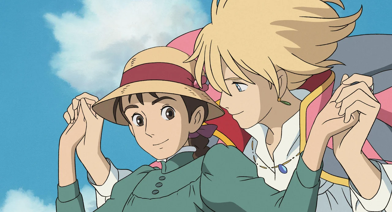 Sophie and Howl hold hands against a bright blue sky in Howl’s Moving Castle.