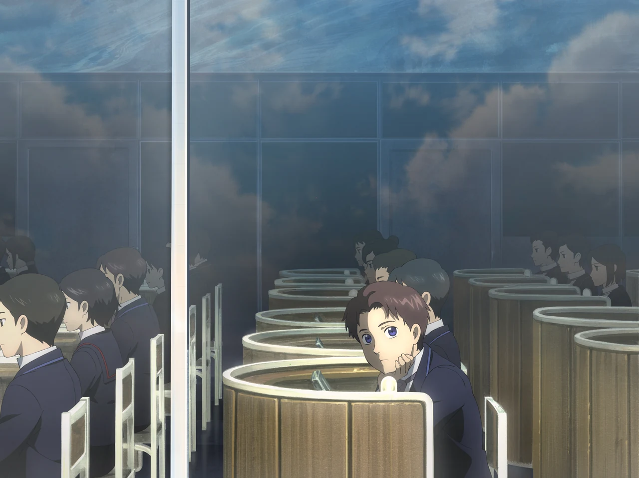 Age rests his cheek on his hand in a classroom of curved desks, looking towards the window while the other pupils face forward.