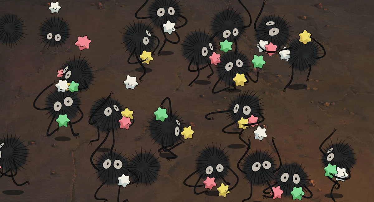 Small black soot workers hold colourful star-shaped sweets.