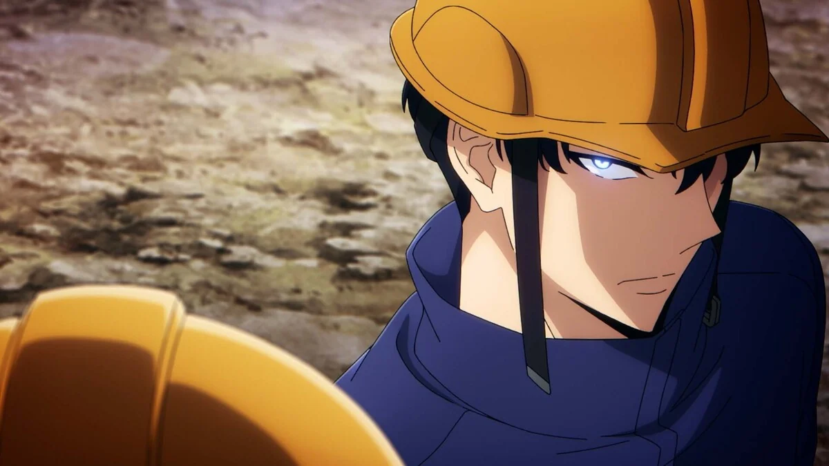 Jinwoo wears an orange hardhat and dark work clothes, with rocky ground behind him.